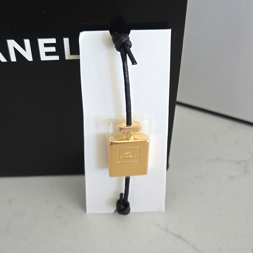 Brand new never used CHANEL bracelet gold bottle charm N°5 adjustable black cord